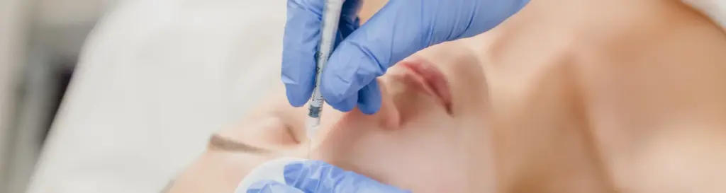 Enfermera realizando tratamiento de estética facial en clínica para ilustrar las salidas profesionales de la enfermería dermoestética.